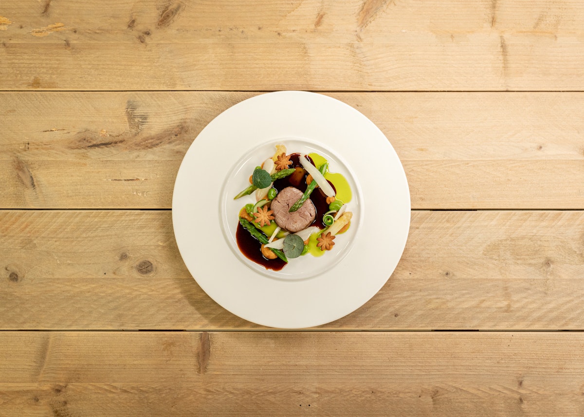 De Werf Sous vide gegaarde lamsfilet asperge crème van zoete aardappel lams jús bieslook olie